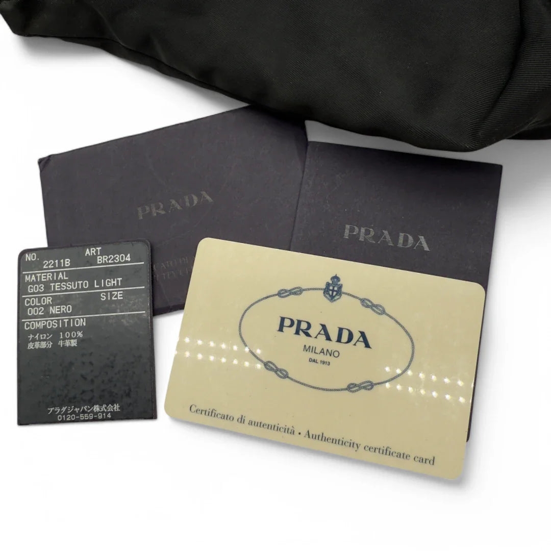 https://cdn.shopify.com/s/files/1/0564/9376/8855/files/Prada_Handtasche_Halbmond_Form_schwarze_Lederecken_Nylon_schwarz_vintage_designer_handbag_4213.webp?v=1741796308