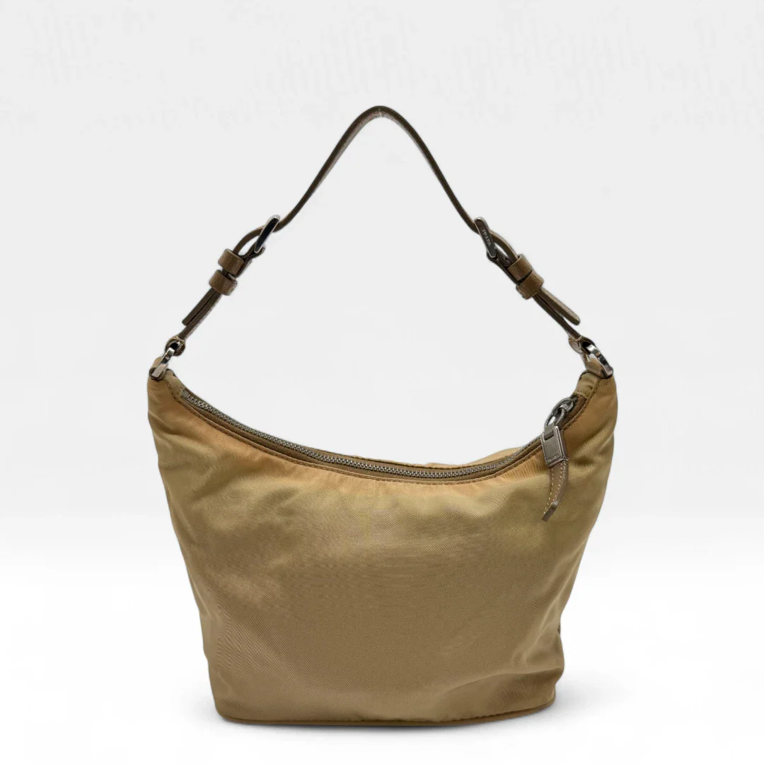 https://cdn.shopify.com/s/files/1/0564/9376/8855/files/Prada_Handtasche_Halbmond_aus_Nylon_beige_second_hand_designer_handbag3642.webp?v=1757671284