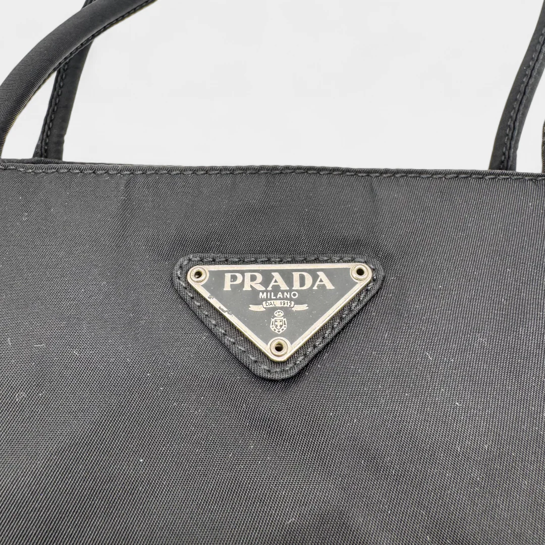 https://cdn.shopify.com/s/files/1/0564/9376/8855/files/Prada_Handtasche_Nylon_schwarz1740.webp?v=1759408449