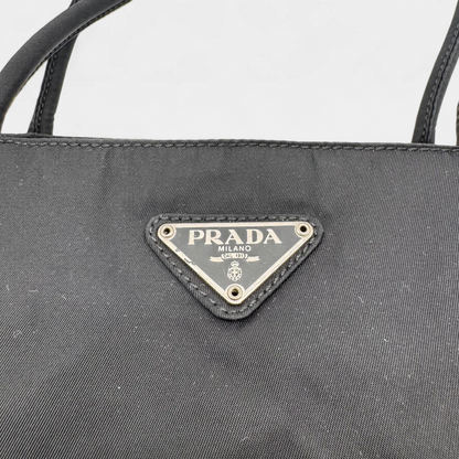 https://cdn.shopify.com/s/files/1/0564/9376/8855/files/Prada_Handtasche_Nylon_schwarz1740.webp?v=1759408449