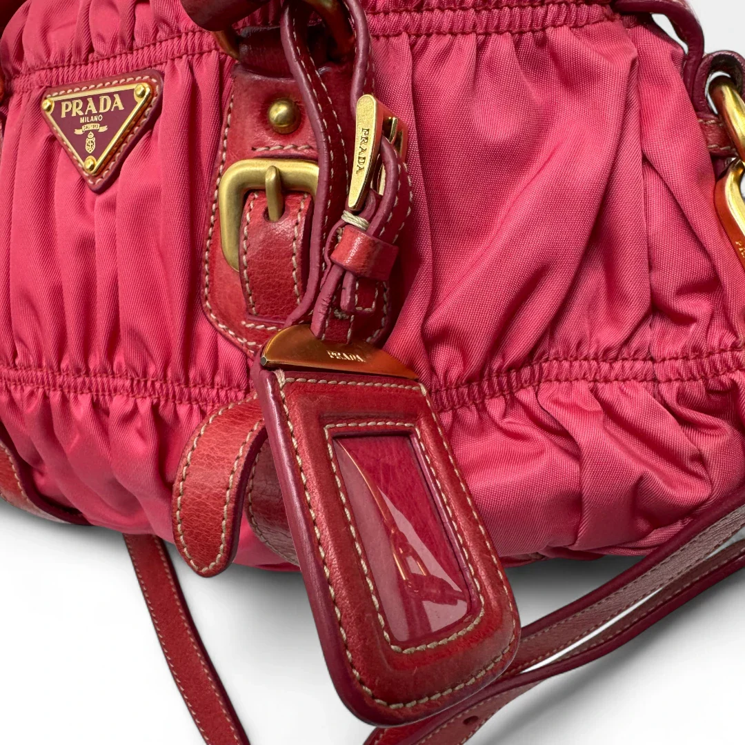 https://cdn.shopify.com/s/files/1/0564/9376/8855/files/Prada_Handtasche_Pocono_aus_Nylon_pink_second_hand_designer_handbag3398.webp?v=1757505484