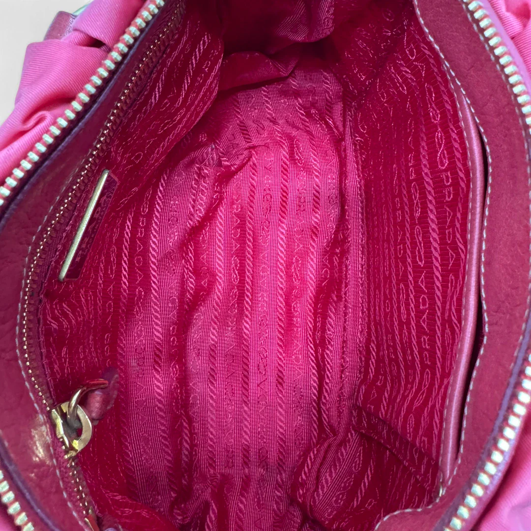https://cdn.shopify.com/s/files/1/0564/9376/8855/files/Prada_Handtasche_Pocono_aus_Nylon_pink_second_hand_designer_handbag3399.webp?v=1757505483
