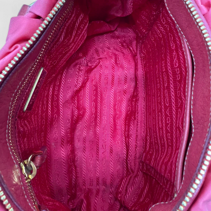 https://cdn.shopify.com/s/files/1/0564/9376/8855/files/Prada_Handtasche_Pocono_aus_Nylon_pink_second_hand_designer_handbag3399.webp?v=1757505483