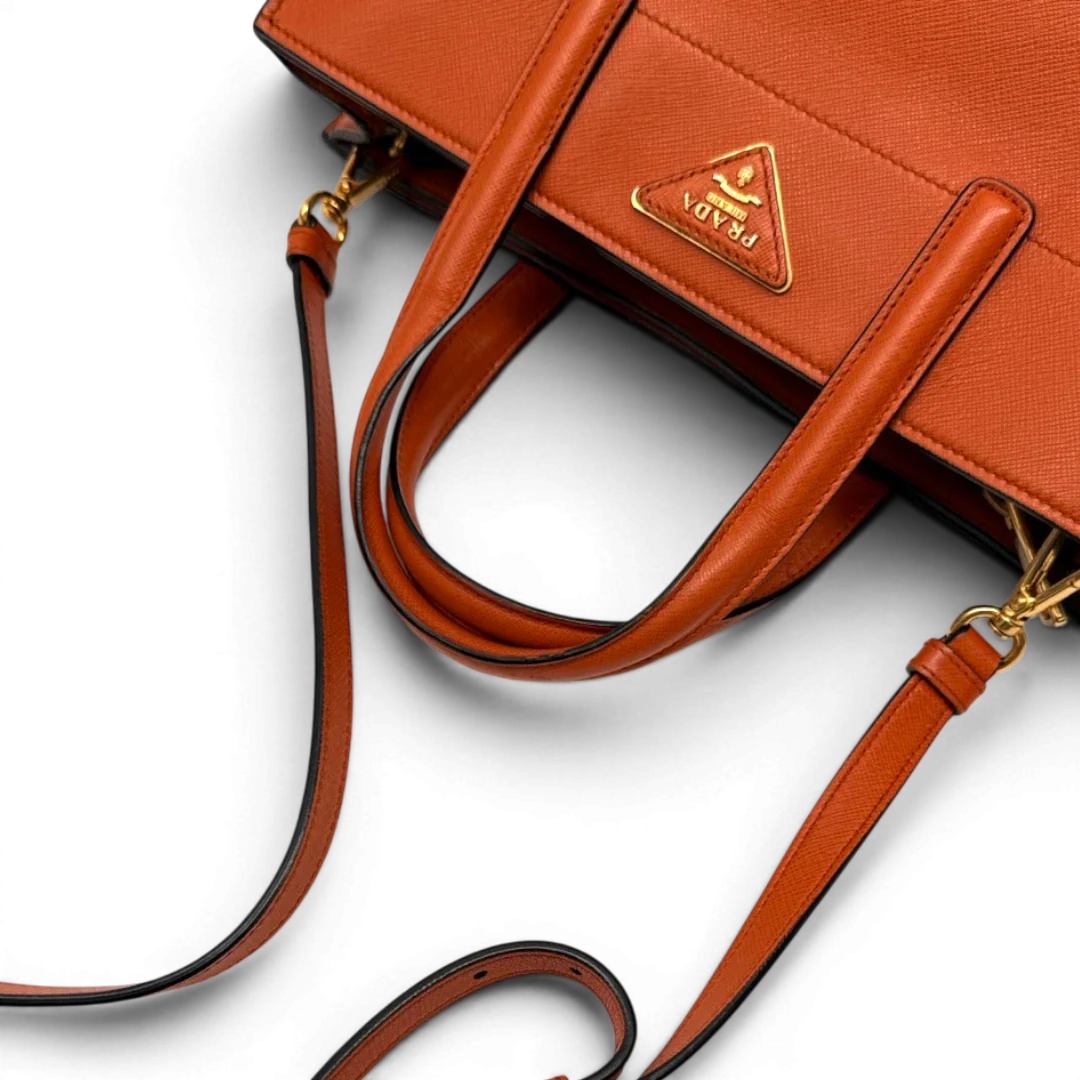 https://cdn.shopify.com/s/files/1/0564/9376/8855/files/Prada_Handtasche_Triple_Pocket_aus_Leder_papaya_orange_17.webp?v=1783516495