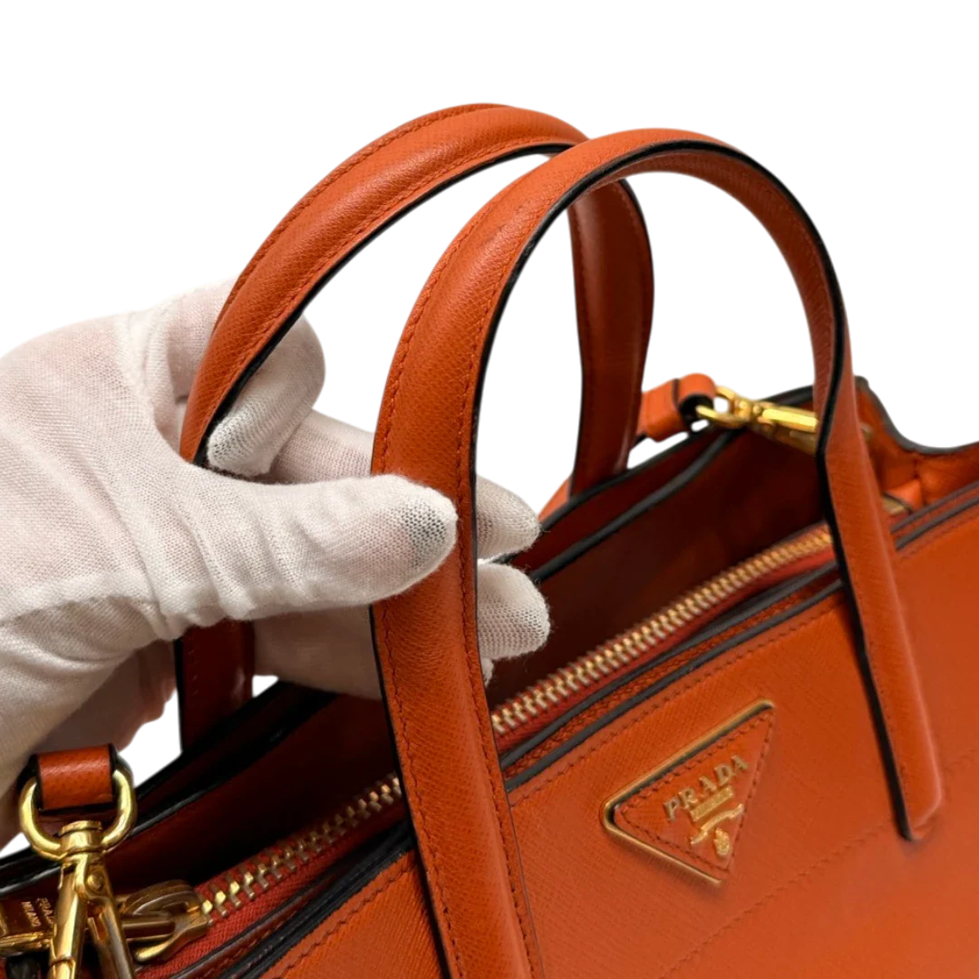 https://cdn.shopify.com/s/files/1/0564/9376/8855/files/Prada_Handtasche_Triple_Pocket_aus_Leder_papaya_orange_18.webp?v=1783516495