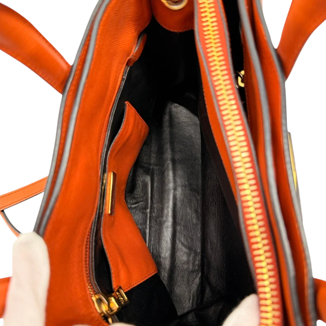https://cdn.shopify.com/s/files/1/0564/9376/8855/files/Prada_Handtasche_Triple_Pocket_aus_Leder_papaya_orange_20.webp?v=1783516495
