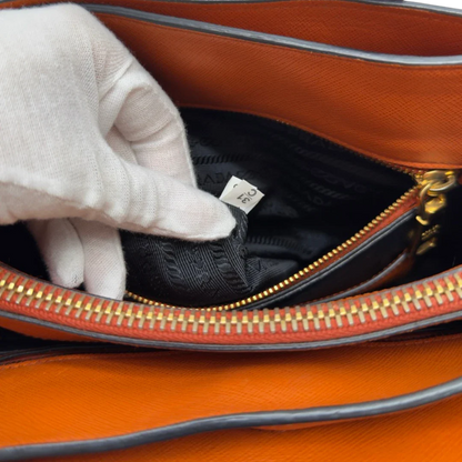 https://cdn.shopify.com/s/files/1/0564/9376/8855/files/Prada_Handtasche_Triple_Pocket_aus_Leder_papaya_orange_26.webp?v=1783516495