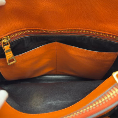 https://cdn.shopify.com/s/files/1/0564/9376/8855/files/Prada_Handtasche_Triple_Pocket_aus_Leder_papaya_orange_29.webp?v=1783516495