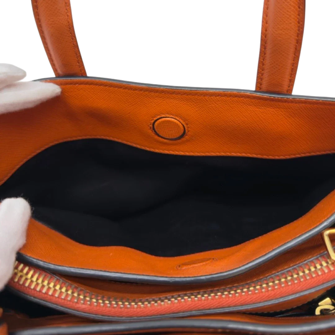 https://cdn.shopify.com/s/files/1/0564/9376/8855/files/Prada_Handtasche_Triple_Pocket_aus_Leder_papaya_orange_31.webp?v=1783516495