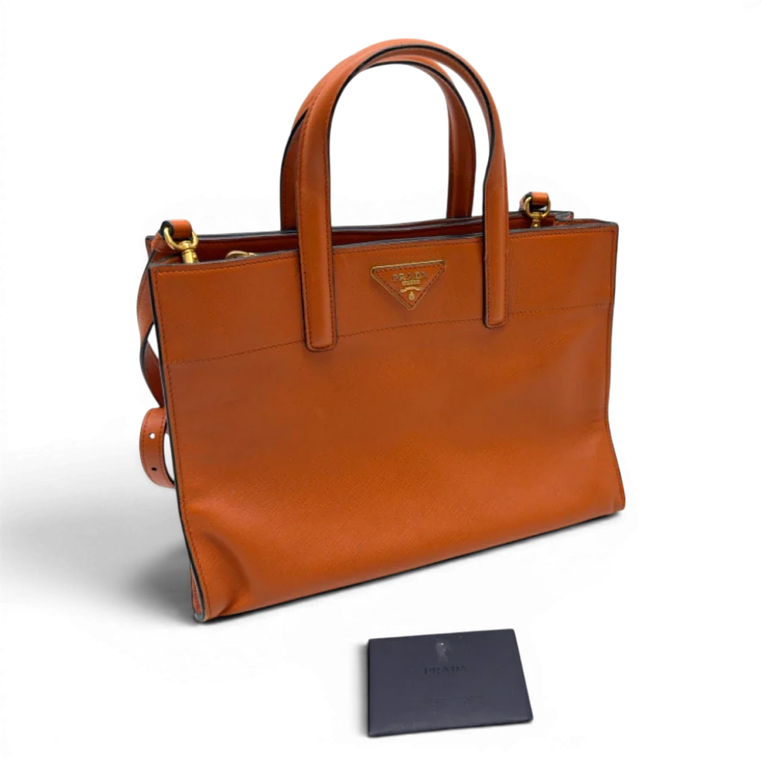 https://cdn.shopify.com/s/files/1/0564/9376/8855/files/Prada_Handtasche_Triple_Pocket_aus_Leder_papaya_orange_32.webp?v=1783516495