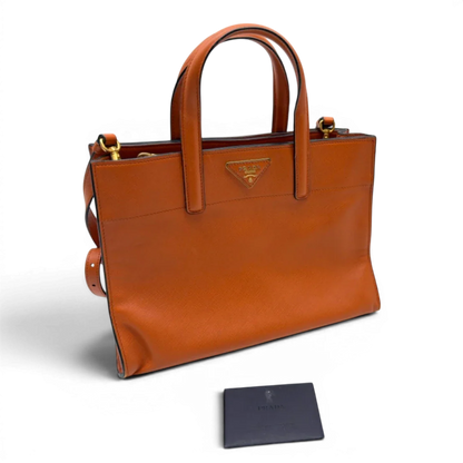 https://cdn.shopify.com/s/files/1/0564/9376/8855/files/Prada_Handtasche_Triple_Pocket_aus_Leder_papaya_orange_32.webp?v=1783516495