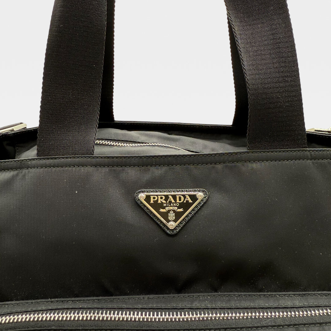 https://cdn.shopify.com/s/files/1/0564/9376/8855/files/Prada_Handtasche___Wickeltasche_aus_Re-Nylon_schwarz_handbag_6135.webp?v=1766106413