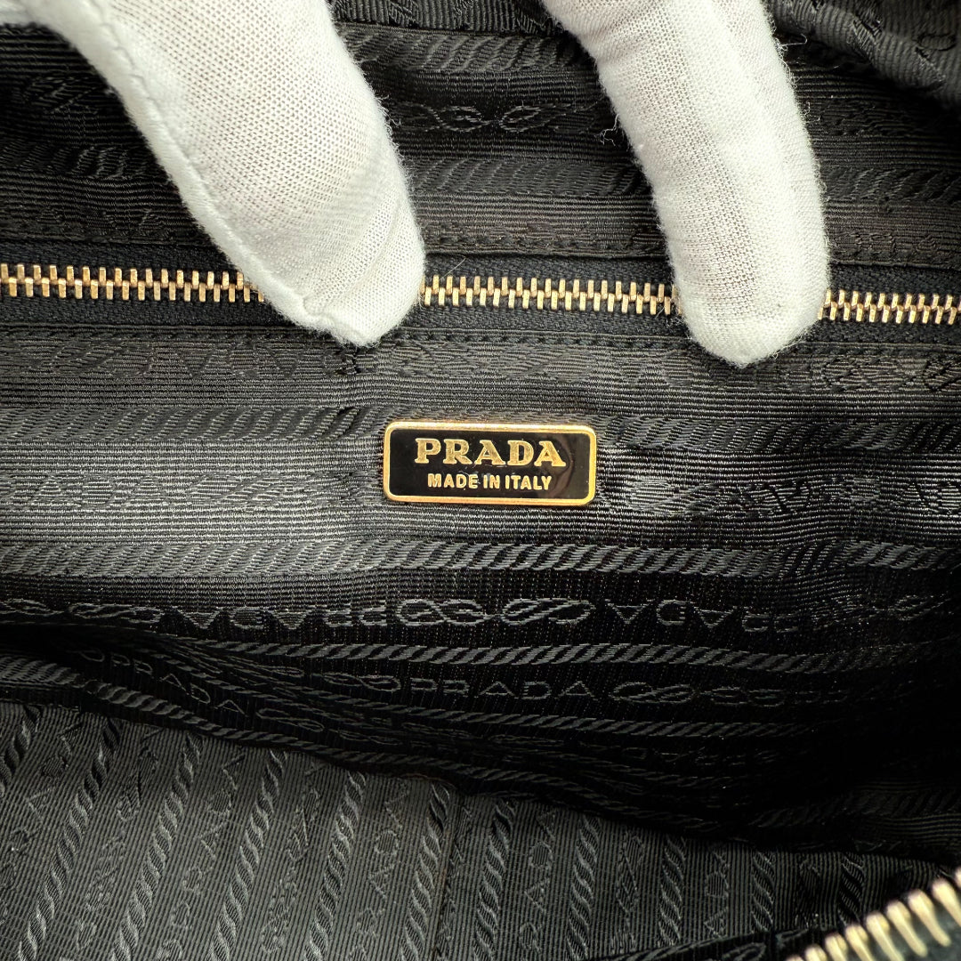 https://cdn.shopify.com/s/files/1/0564/9376/8855/files/Prada_Handtasche_aus_Nylon_schwarz_vintage_handbag5195.webp?v=1765381229