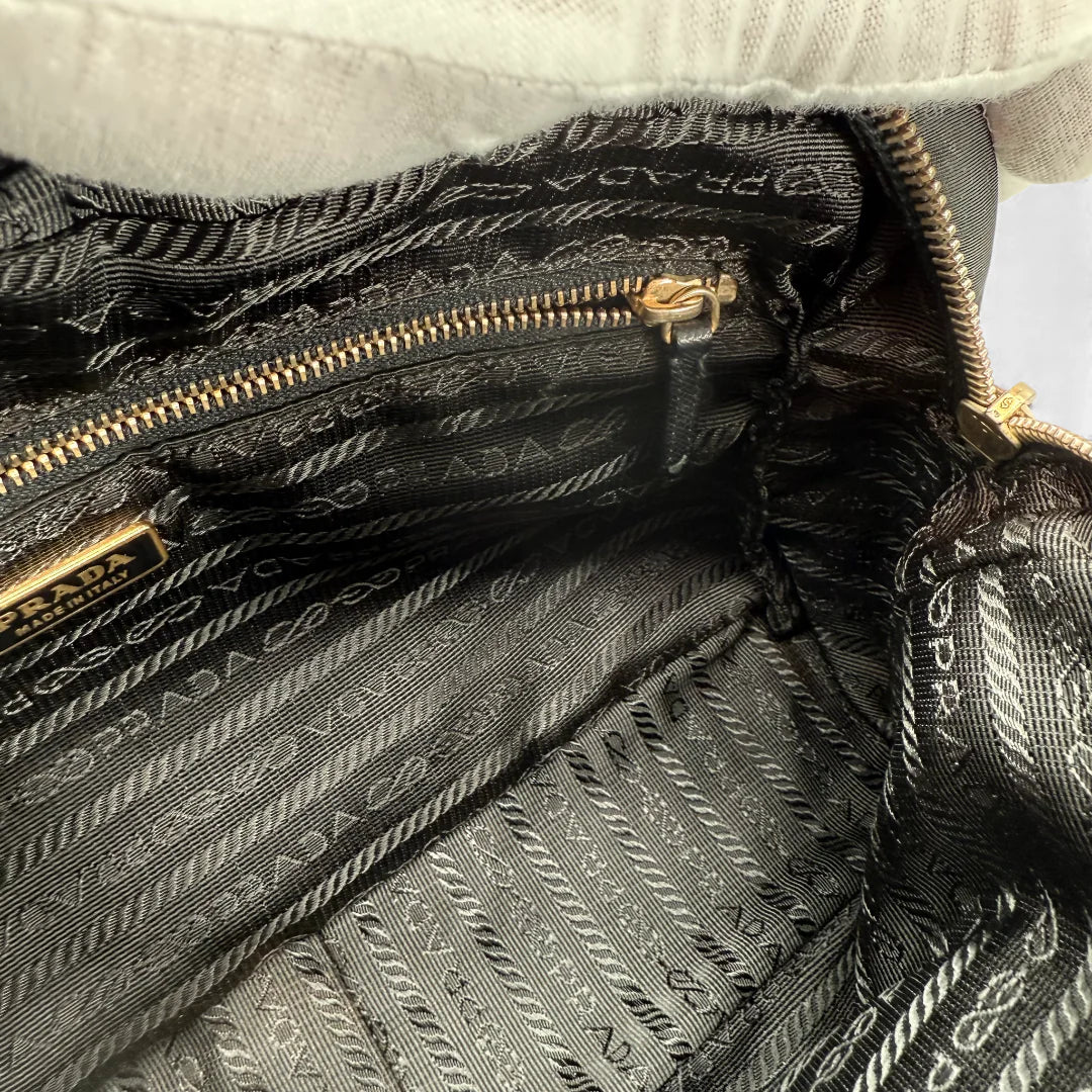 https://cdn.shopify.com/s/files/1/0564/9376/8855/files/Prada_Handtasche_aus_Nylon_schwarz_vintage_handbag5196.webp?v=1765381230