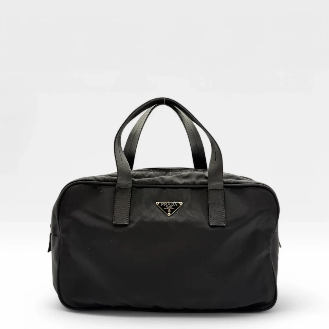 https://cdn.shopify.com/s/files/1/0564/9376/8855/files/Prada_Handtasche_rechteckig_aus_Nylon_schwarz_vintage_luxury_handbag_4326.webp?v=1744729597