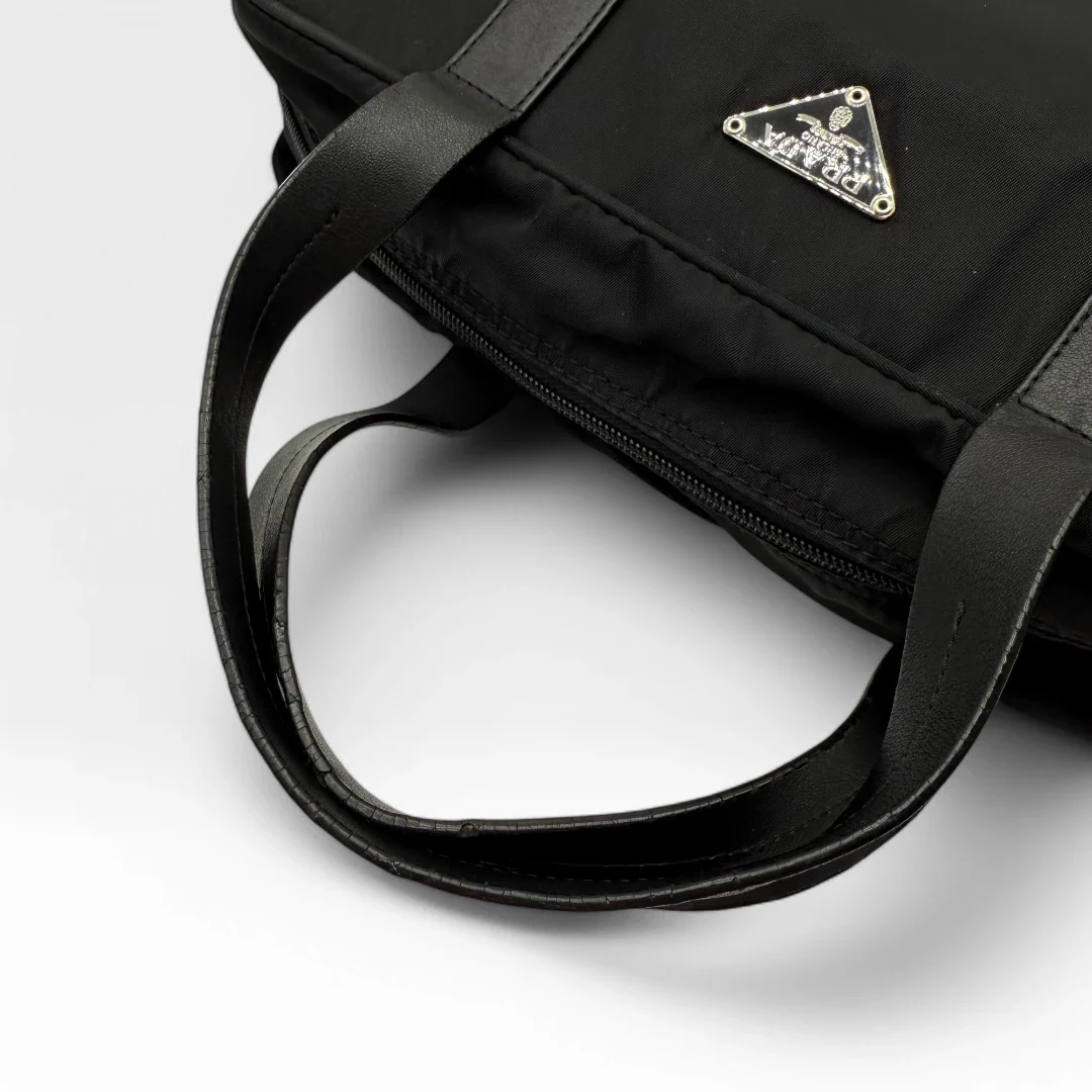 https://cdn.shopify.com/s/files/1/0564/9376/8855/files/Prada_Handtasche_rechteckig_aus_Nylon_schwarz_vintage_luxury_handbag_4344.webp?v=1744967277