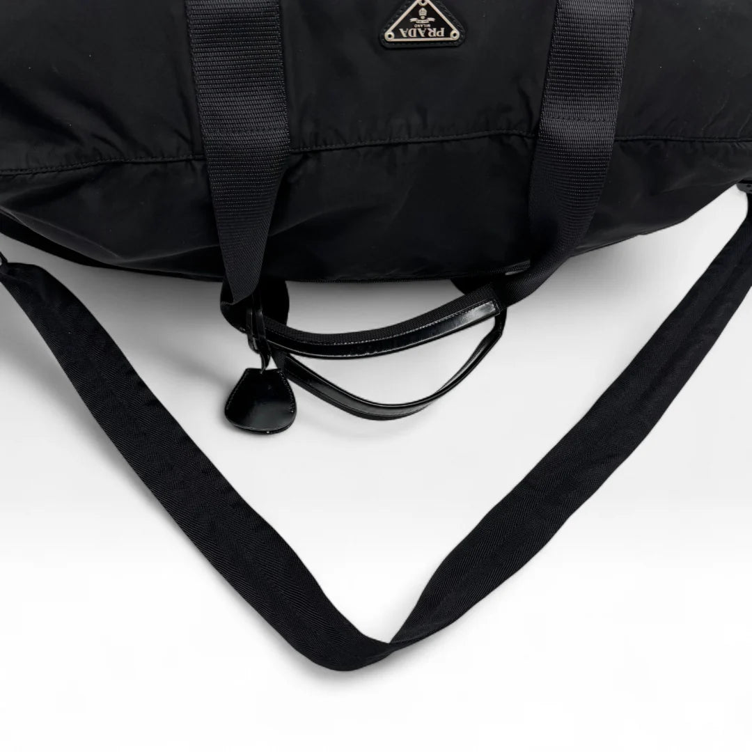 https://cdn.shopify.com/s/files/1/0564/9376/8855/files/Prada_Reisetasche_50_aus_Nylon_schwarz_vintage_dufflebag5158.webp?v=1761262441