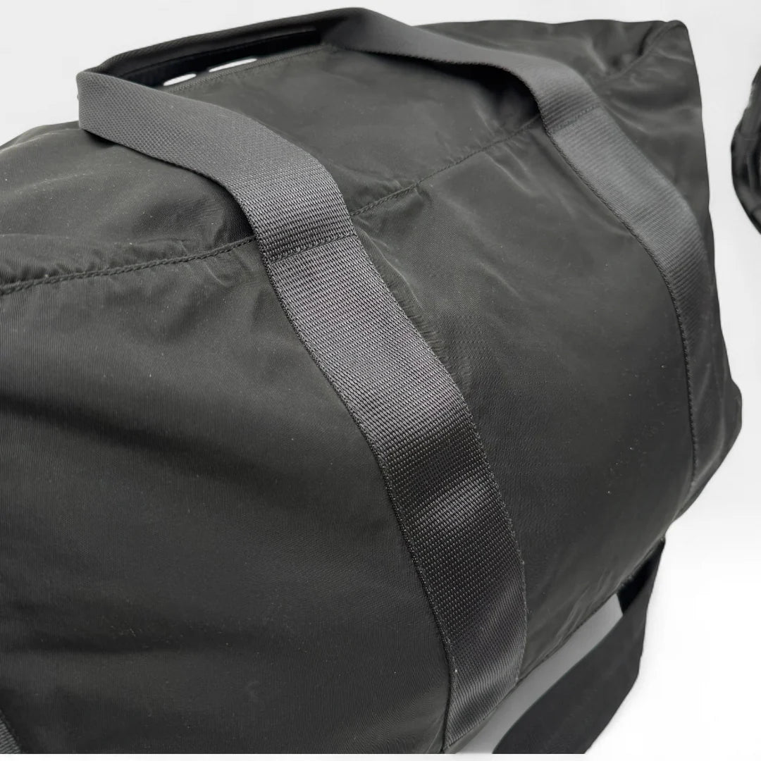 https://cdn.shopify.com/s/files/1/0564/9376/8855/files/Prada_Reisetasche_50_aus_Nylon_schwarz_vintage_dufflebag5164.webp?v=1761262442
