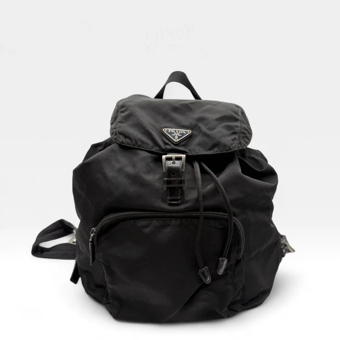 https://cdn.shopify.com/s/files/1/0564/9376/8855/files/Prada_Rucksack_mit_Schnalle_aus_Nylon_schwarz_second_hand_designer_backpack3154.webp?v=1753348302