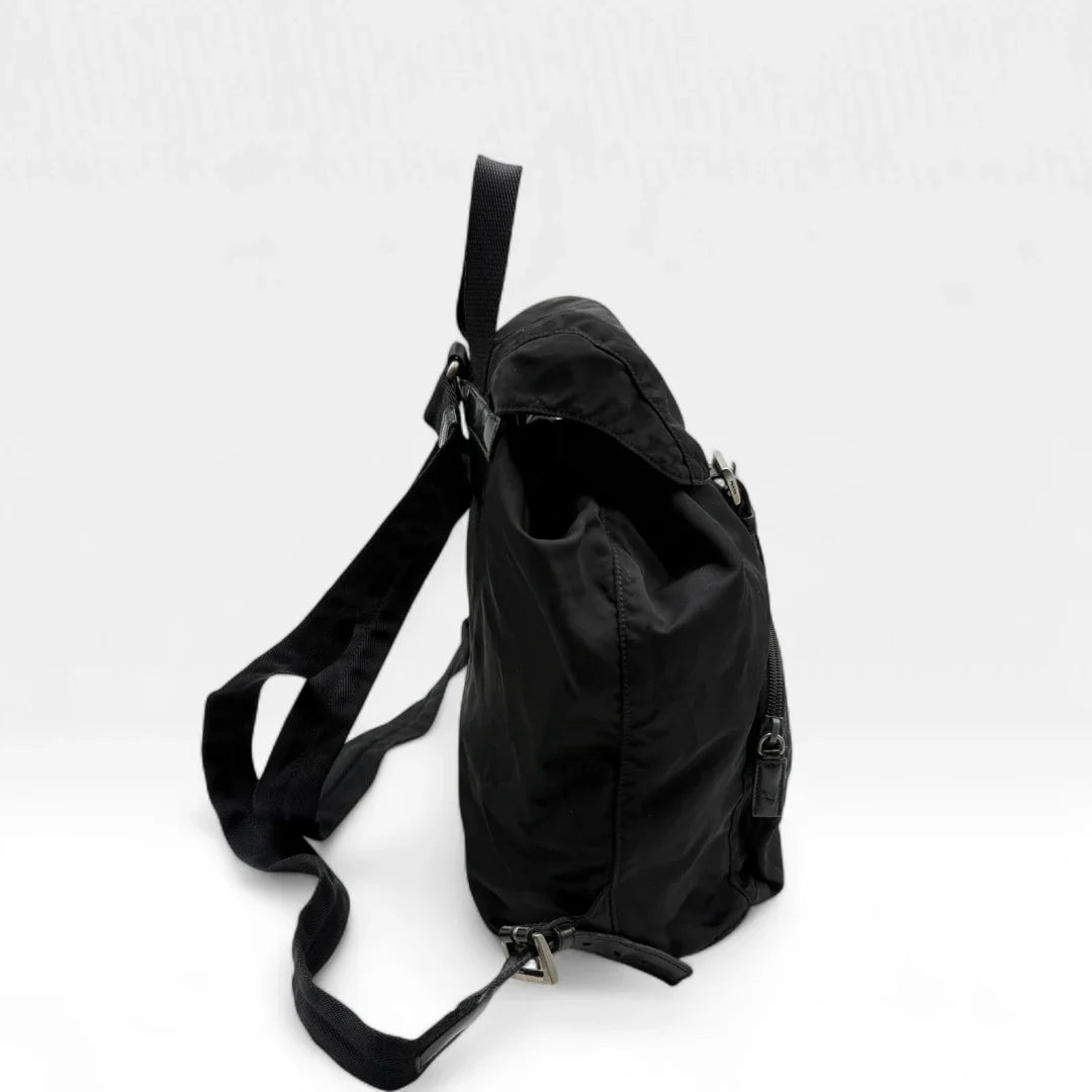 https://cdn.shopify.com/s/files/1/0564/9376/8855/files/Prada_Rucksack_mit_Schnalle_aus_Nylon_schwarz_second_hand_designer_backpack3155.webp?v=1753348302
