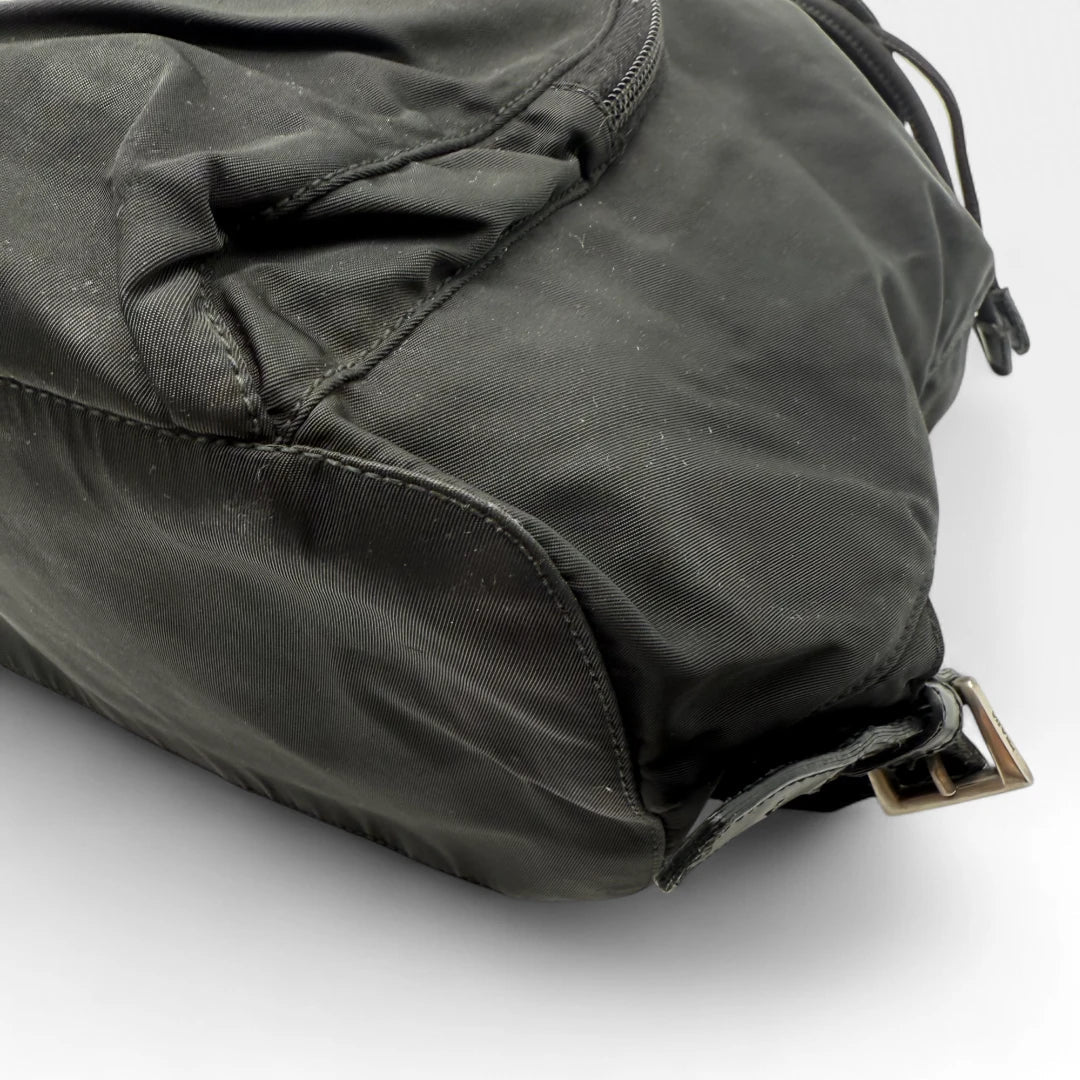 https://cdn.shopify.com/s/files/1/0564/9376/8855/files/Prada_Rucksack_mit_Schnalle_aus_Nylon_schwarz_second_hand_designer_backpack3162.webp?v=1753348226