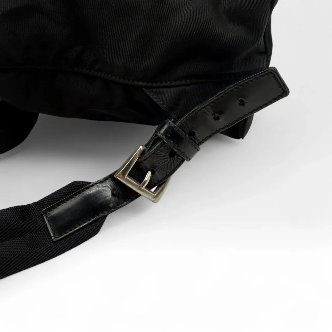 https://cdn.shopify.com/s/files/1/0564/9376/8855/files/Prada_Rucksack_mit_Schnalle_aus_Nylon_schwarz_second_hand_designer_backpack3166.webp?v=1753348225