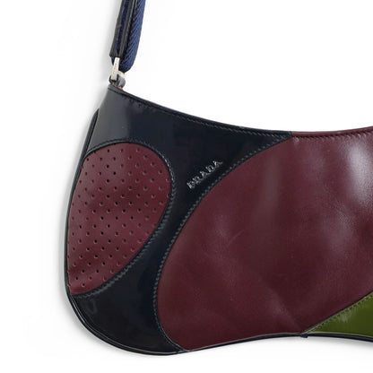Prada SS 2000 Vitello Drive shoulder bag in burgundy leather with navy and green patent leather panels and perforated leather sections. Available at Artefact Archive.