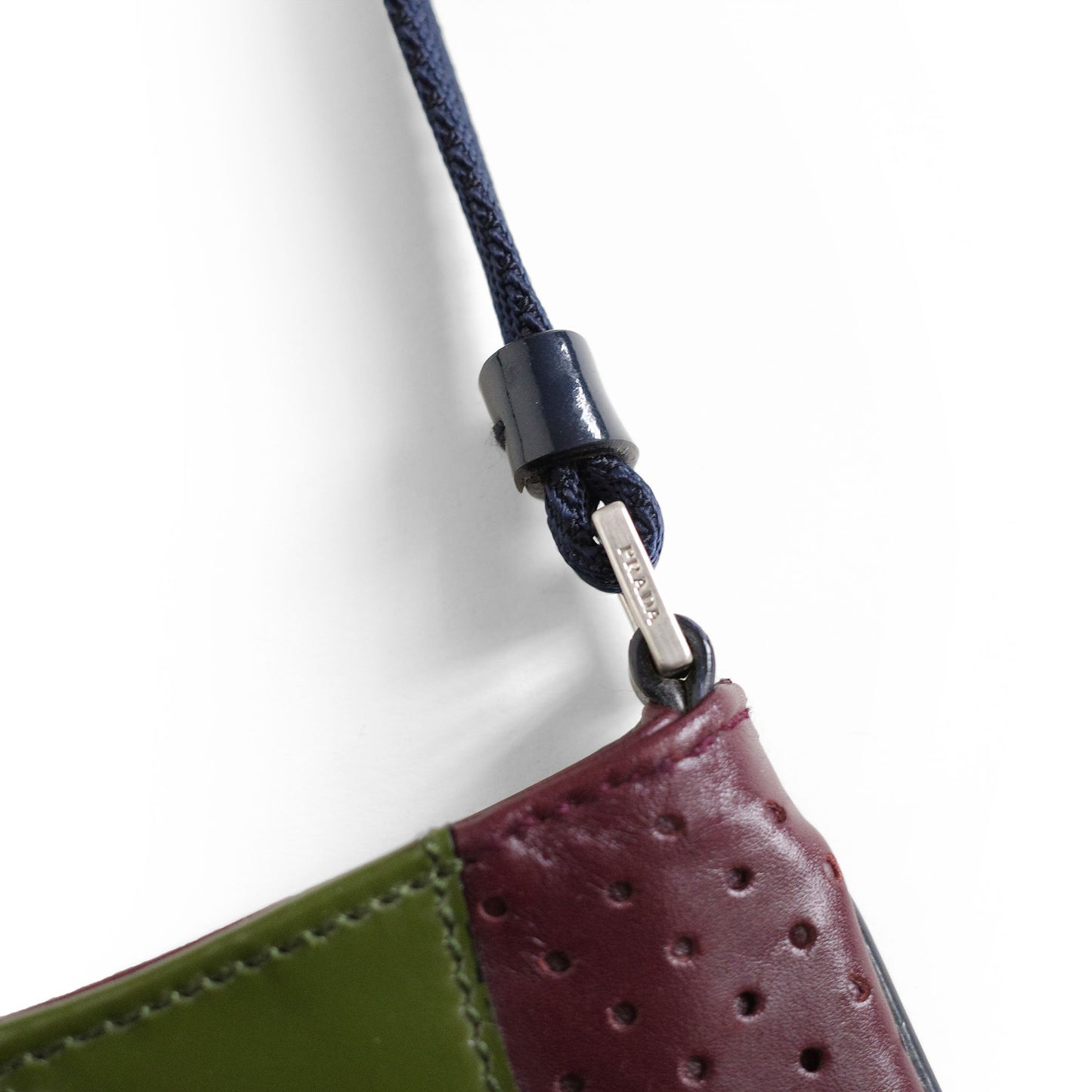 Prada SS 2000 Vitello Drive shoulder bag in burgundy leather with navy and green patent leather panels and perforated leather sections. Available at Artefact Archive.