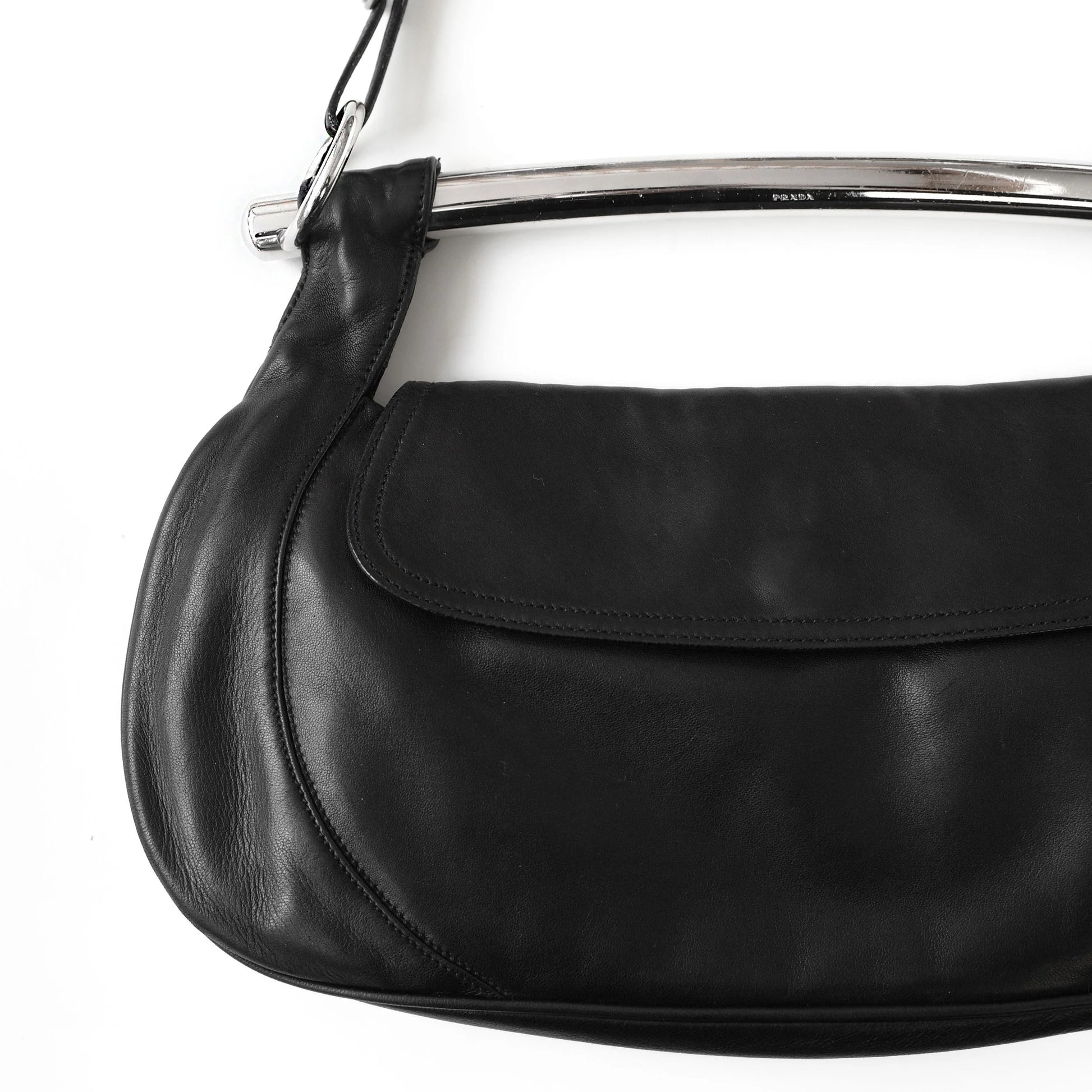 https://images.squarespace-cdn.com/content/v1/673cad159307f210013ba2f7/b1edfb09-0945-4721-b90f-17bd4c1dd36a/Prada_SS2003_BlackNappaLeatherMetalBarBag_2.jpg