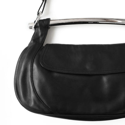 https://images.squarespace-cdn.com/content/v1/673cad159307f210013ba2f7/b1edfb09-0945-4721-b90f-17bd4c1dd36a/Prada_SS2003_BlackNappaLeatherMetalBarBag_2.jpg