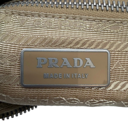 https://cdn.shopify.com/s/files/1/0564/9376/8855/files/Prada_Schultertasche_Hobo_Croissant_aus_Nylon_beige_vintage7748.webp?v=1780487479