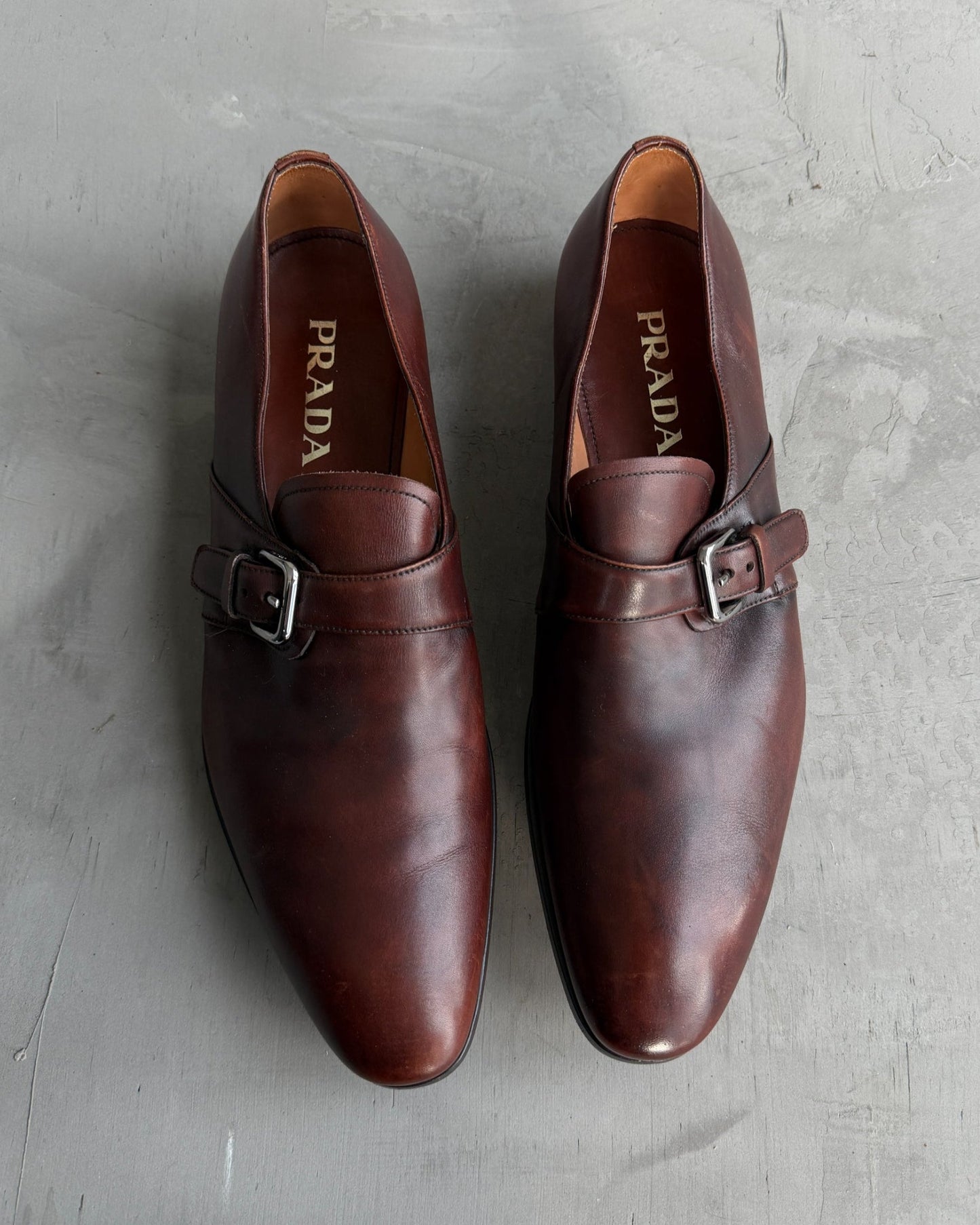 Prada Buckle Leather Derbys – UK 9-on a concrete background