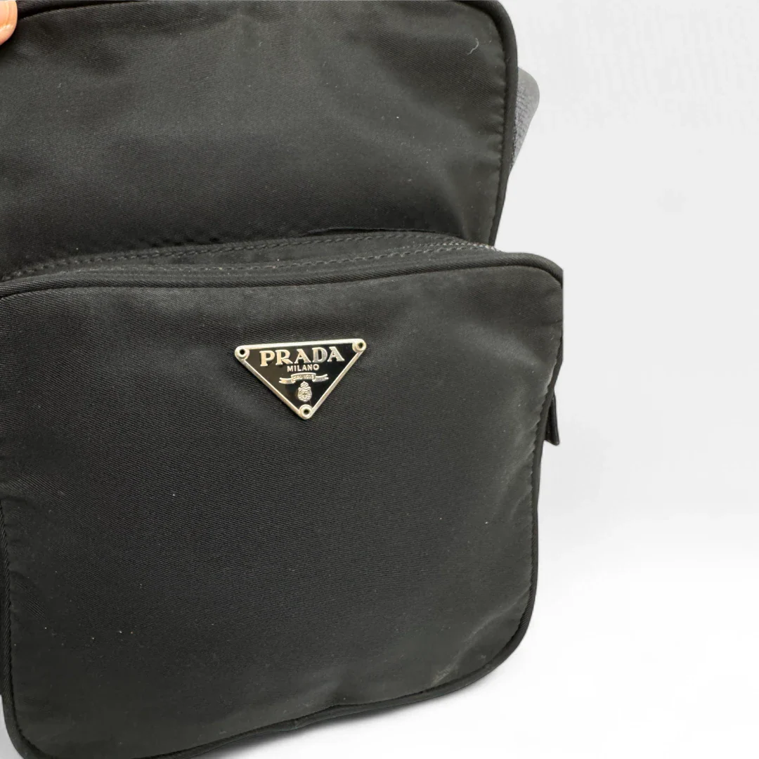 https://cdn.shopify.com/s/files/1/0564/9376/8855/files/Prada_Umhaengetasche_mit_extra_Fach_aus_Nylon_schwarz_second_hand_designer_crossbody0679.webp?v=1752142581