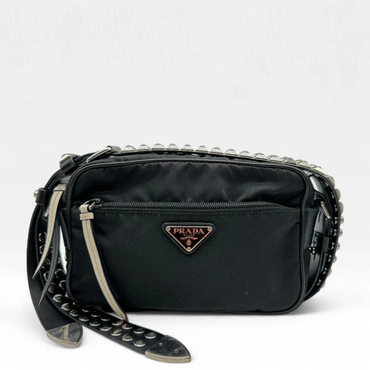 https://cdn.shopify.com/s/files/1/0564/9376/8855/files/Prada_Umhangetasche_AW18_mit_Nieten_aus_Nylon_schwarz_vintage_crossbody8168.webp?v=1758632894