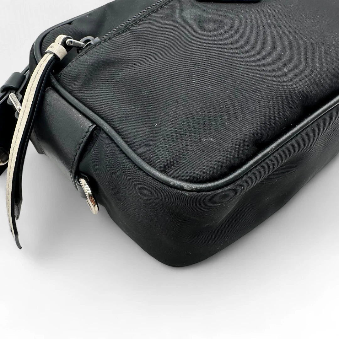 https://cdn.shopify.com/s/files/1/0564/9376/8855/files/Prada_Umhangetasche_AW18_mit_Nieten_aus_Nylon_schwarz_vintage_crossbody8174.webp?v=1758632895