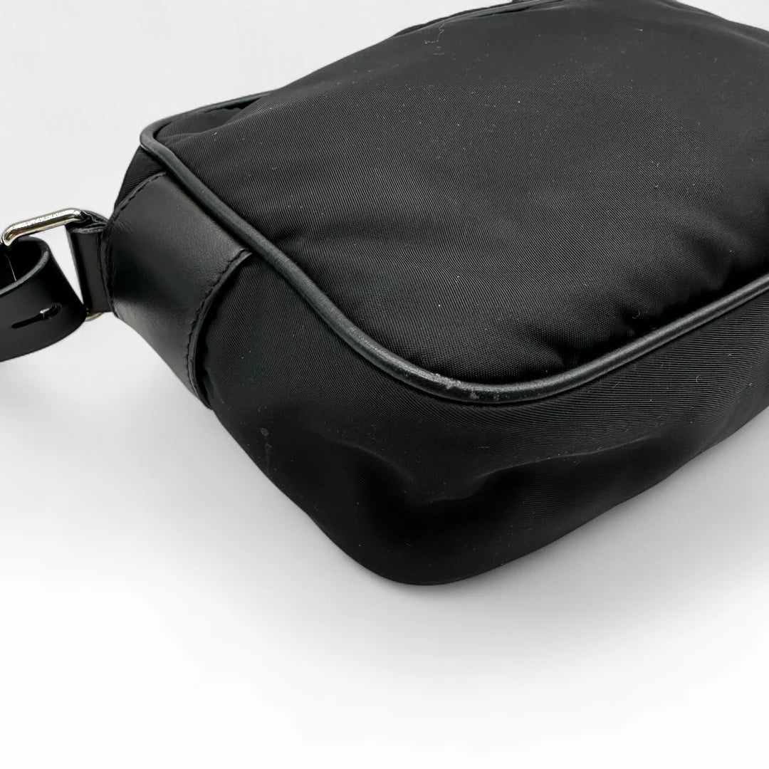 https://cdn.shopify.com/s/files/1/0564/9376/8855/files/Prada_Umhangetasche_AW18_mit_Nieten_aus_Nylon_schwarz_vintage_crossbody8177.webp?v=1758632895