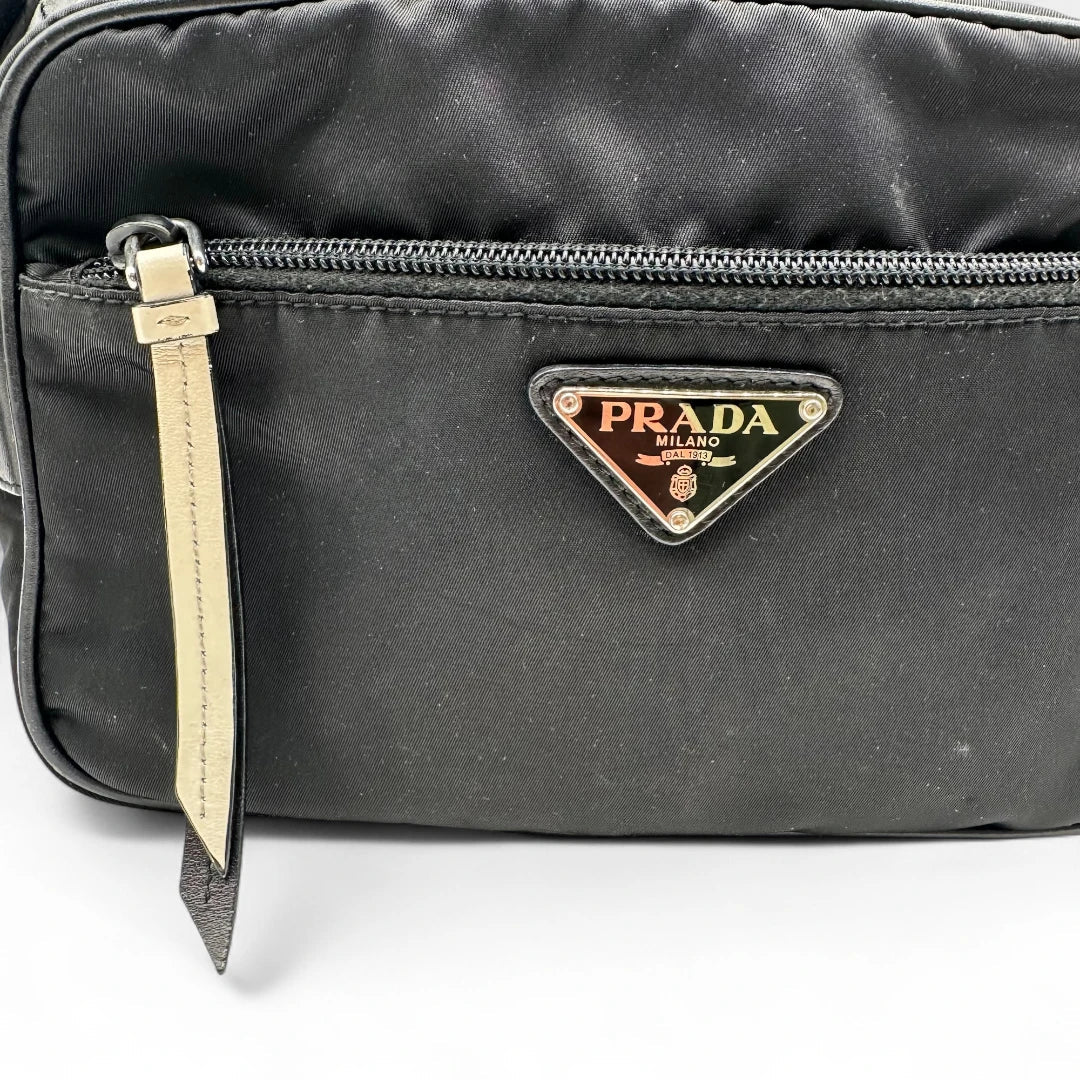 https://cdn.shopify.com/s/files/1/0564/9376/8855/files/Prada_Umhangetasche_AW18_mit_Nieten_aus_Nylon_schwarz_vintage_crossbody8180.webp?v=1758632895