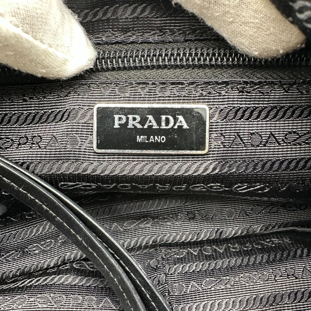 https://cdn.shopify.com/s/files/1/0564/9376/8855/files/Prada_Umhangetasche_AW18_mit_Nieten_aus_Nylon_schwarz_vintage_crossbody8185.webp?v=1758632969