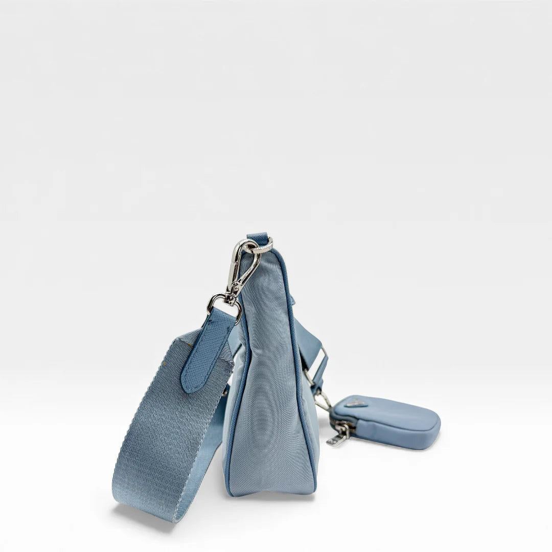 https://cdn.shopify.com/s/files/1/0564/9376/8855/files/Prada_Umhangetasche_Tessuto_Re-Nylon_2005_hellblau_crossbody_5829.webp?v=1765453661