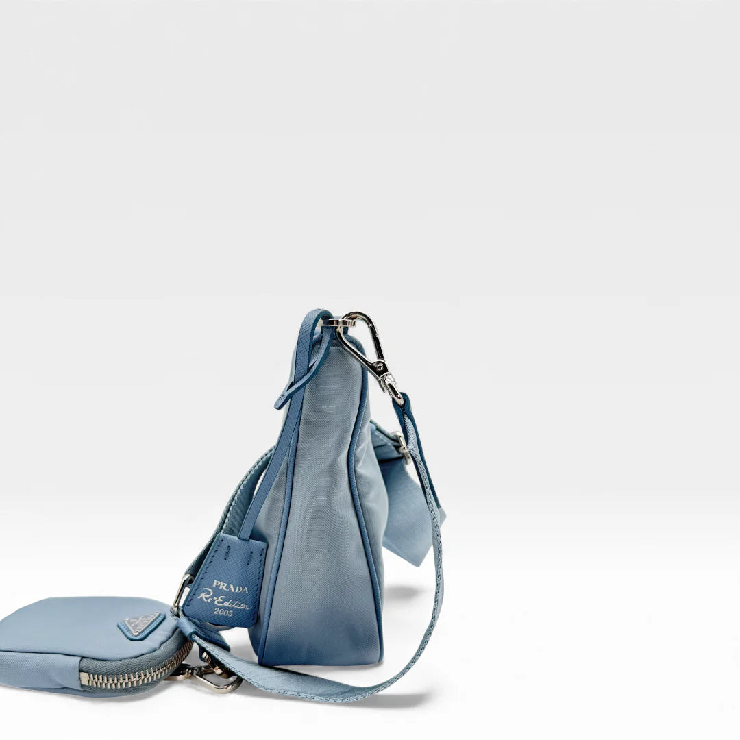 https://cdn.shopify.com/s/files/1/0564/9376/8855/files/Prada_Umhangetasche_Tessuto_Re-Nylon_2005_hellblau_crossbody_5830.webp?v=1765453661