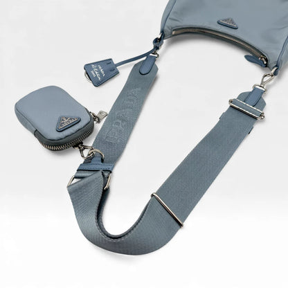 https://cdn.shopify.com/s/files/1/0564/9376/8855/files/Prada_Umhangetasche_Tessuto_Re-Nylon_2005_hellblau_crossbody_5836.webp?v=1765453661