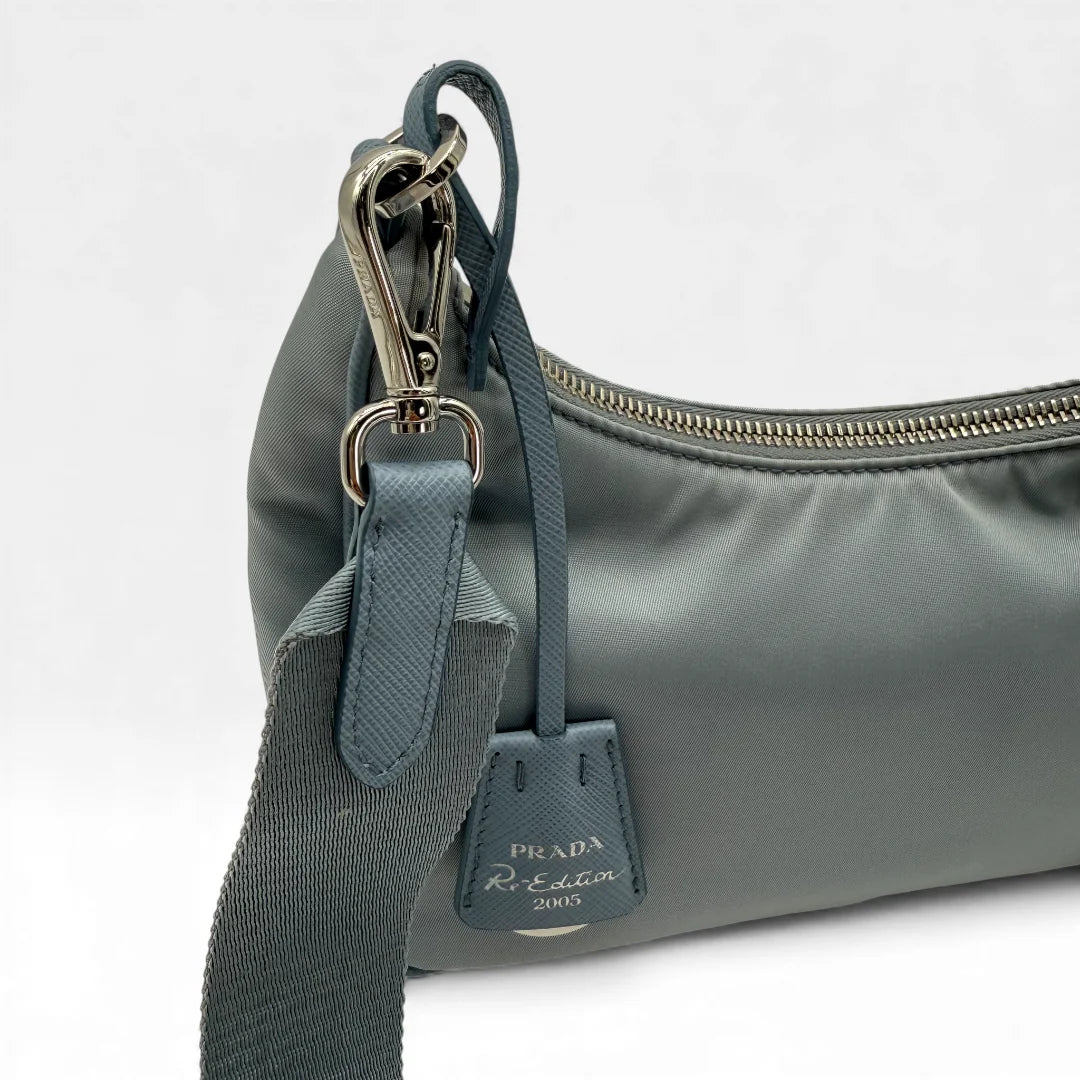 https://cdn.shopify.com/s/files/1/0564/9376/8855/files/Prada_Umhangetasche_Tessuto_Re-Nylon_2005_hellblau_crossbody_5844.webp?v=1765453661