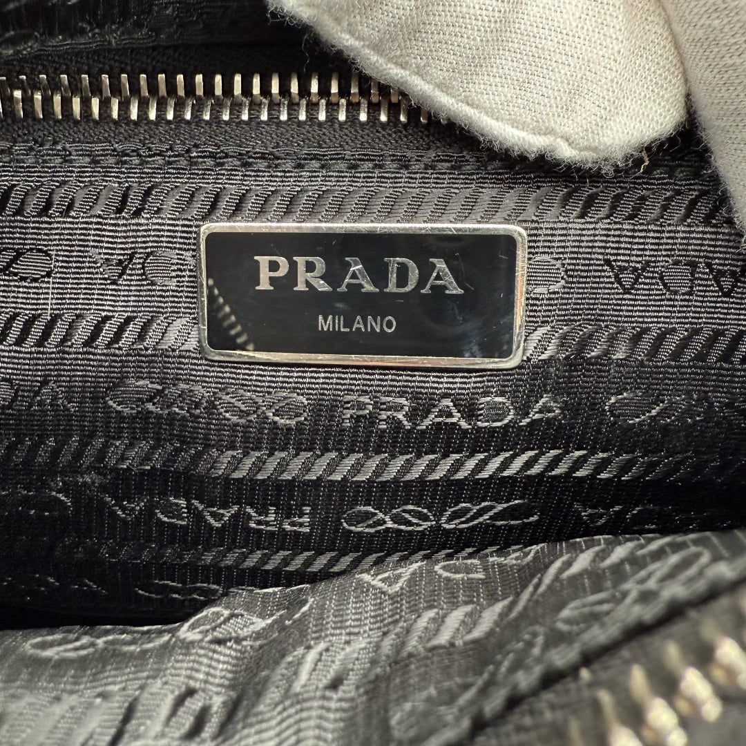 https://cdn.shopify.com/s/files/1/0564/9376/8855/files/Prada_Umhangetasche_Tessuto_Stepp_aus_Nylon_schwarz_vintage_crossbody_5823.webp?v=1765452268