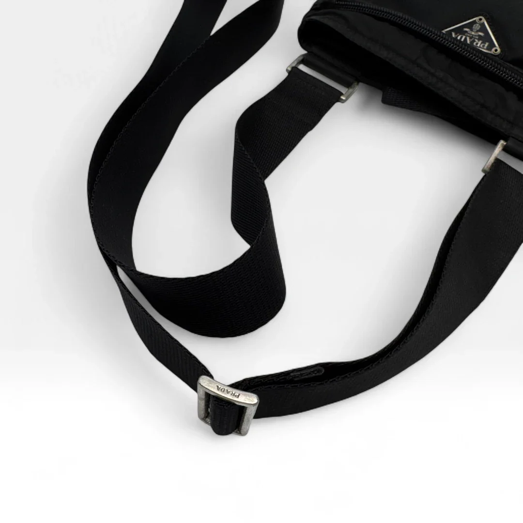https://cdn.shopify.com/s/files/1/0564/9376/8855/files/Prada_Umhangetasche_basic_aus_Nylon_schwarz_vintage_luxury_crossbody3008.webp?v=1757027939