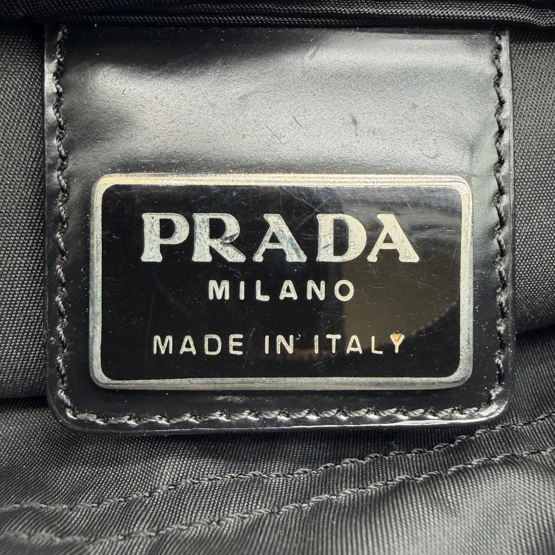 https://cdn.shopify.com/s/files/1/0564/9376/8855/files/Prada_Umhangetasche_basic_small_aus_Nylon_schwarz_vintage8300.webp?v=1781084673