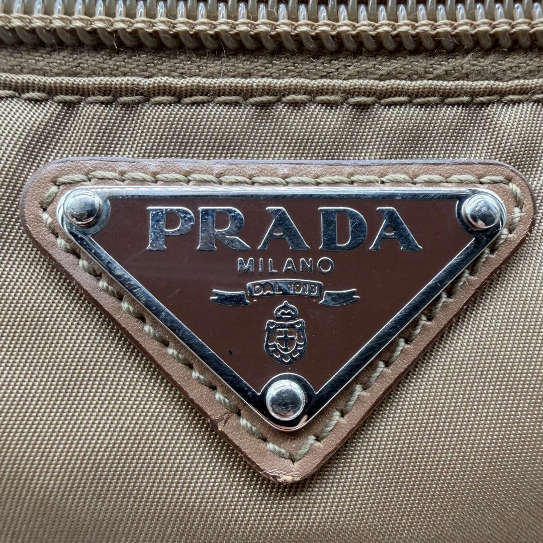 https://cdn.shopify.com/s/files/1/0564/9376/8855/files/Prada_Umhangetasche_rechteckig_small_aus_Nylon_hellbraun_12.webp?v=1782311805