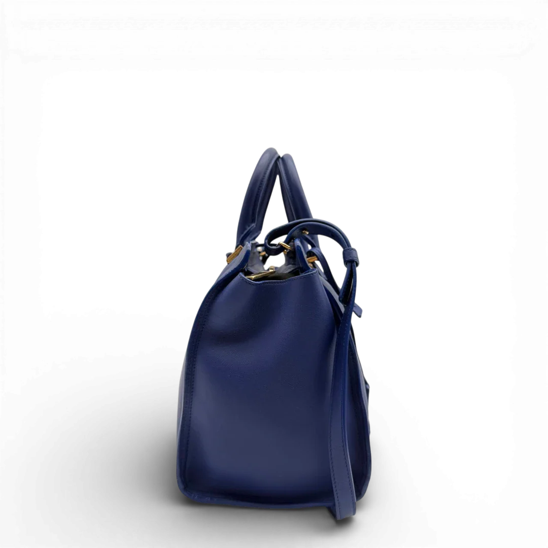 https://cdn.shopify.com/s/files/1/0564/9376/8855/files/Saint_Laurent_Handtasche_Cabbas_mit_Umhangegurt_aus_Leder_blau_vintage2605.webp?v=1773312218