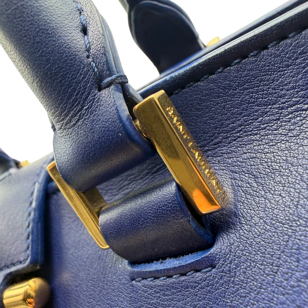 https://cdn.shopify.com/s/files/1/0564/9376/8855/files/Saint_Laurent_Handtasche_Cabbas_mit_Umhangegurt_aus_Leder_blau_vintage2614.webp?v=1773312218