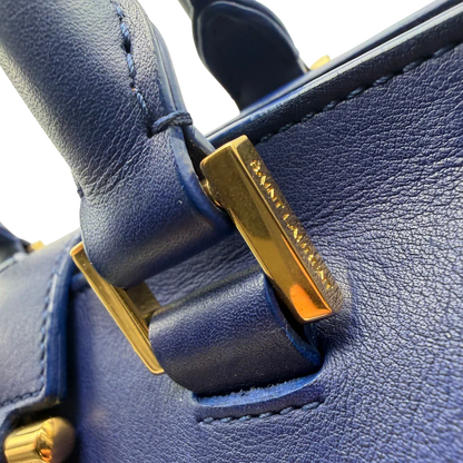 https://cdn.shopify.com/s/files/1/0564/9376/8855/files/Saint_Laurent_Handtasche_Cabbas_mit_Umhangegurt_aus_Leder_blau_vintage2614.webp?v=1773312218