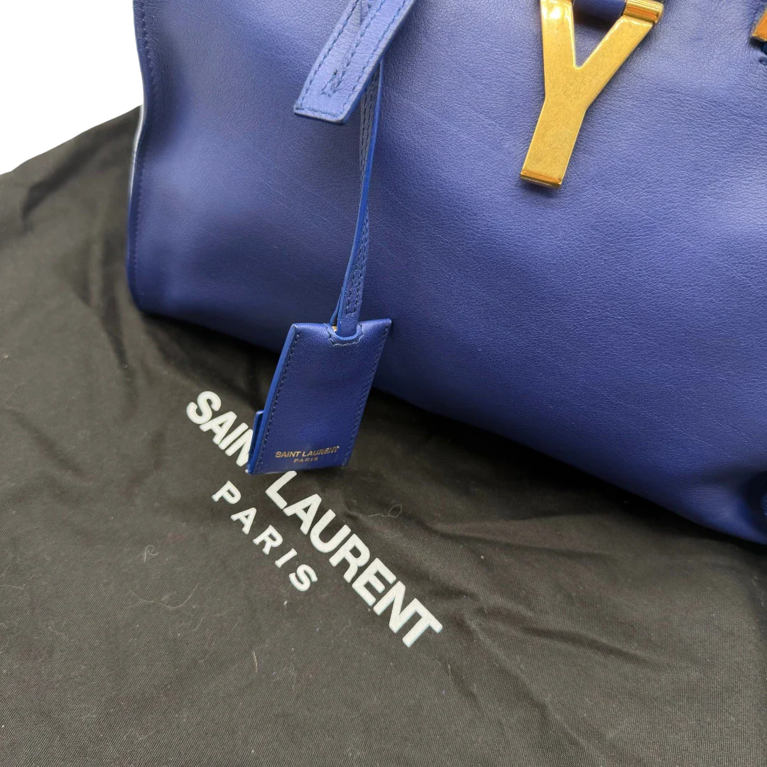 https://cdn.shopify.com/s/files/1/0564/9376/8855/files/Saint_Laurent_Handtasche_Cabbas_mit_Umhangegurt_aus_Leder_blau_vintage2621.webp?v=1773312218